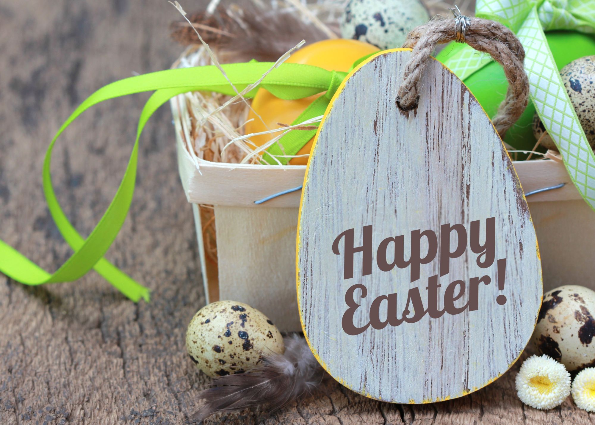 Basket with colorful eggs and a wooden egg that say Happy Easter in brown writing